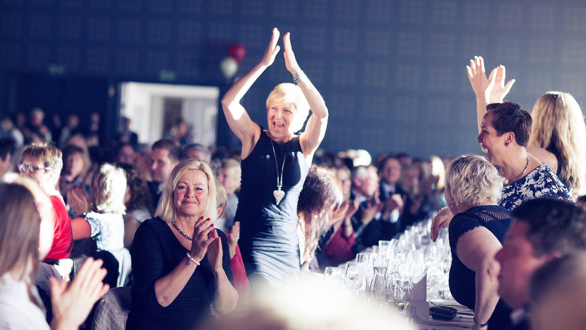 Dame som klapper i hendene over hodet