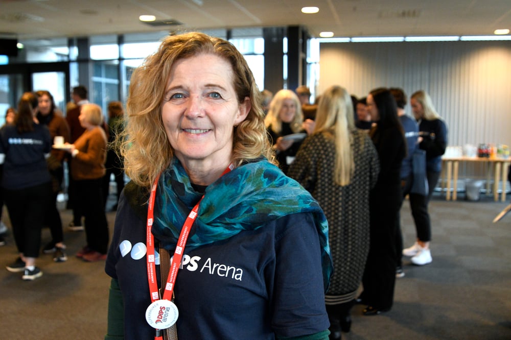 Bilde av en dame som smiler bredt i DIPS Arena t-skjorte - Linda Thorbjørnsen