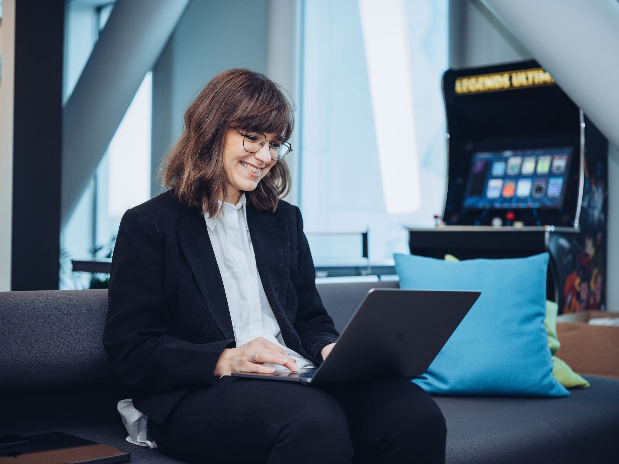 Smilende dame jobber på laptop 1