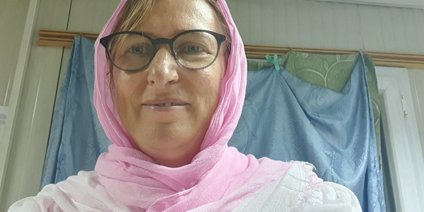 Anca er vel fremme ved sykehuset, og smiler i kledd sjal som ikke viser håret