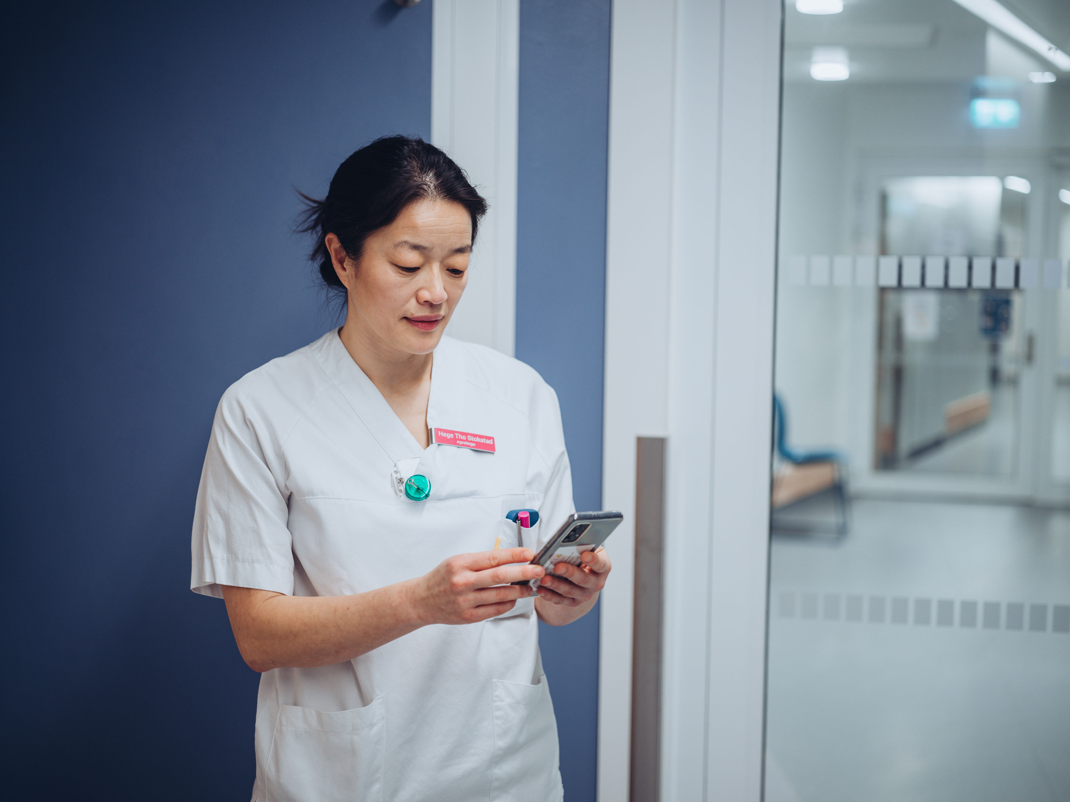 Sykepleier ser på mobil