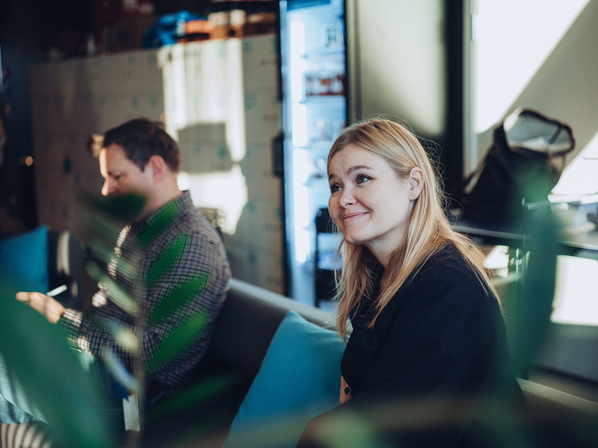 To personer i sofa, smilende dame i fokus