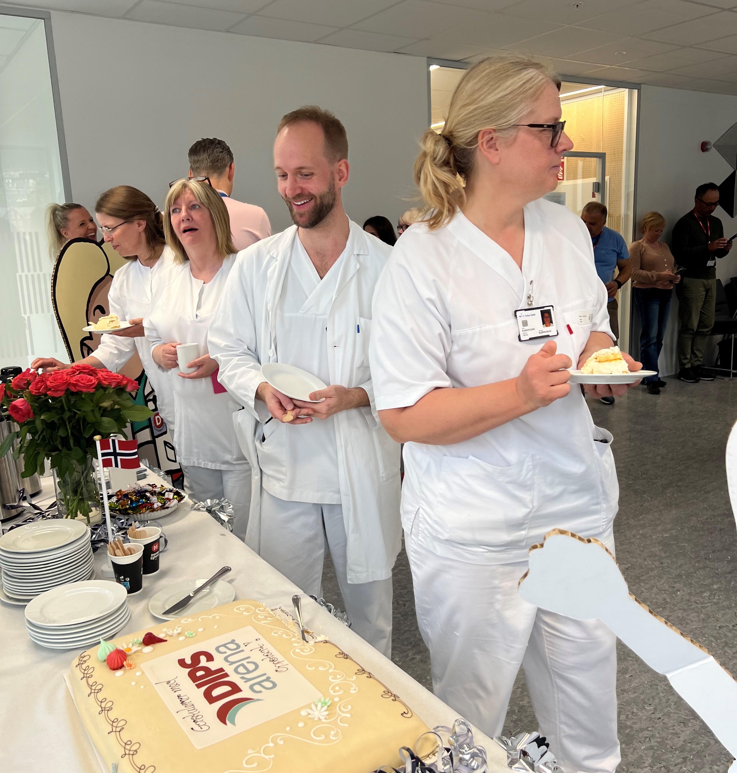 Sykepleiere forsyner seg med marsipankake med DIPS Arena-logo
