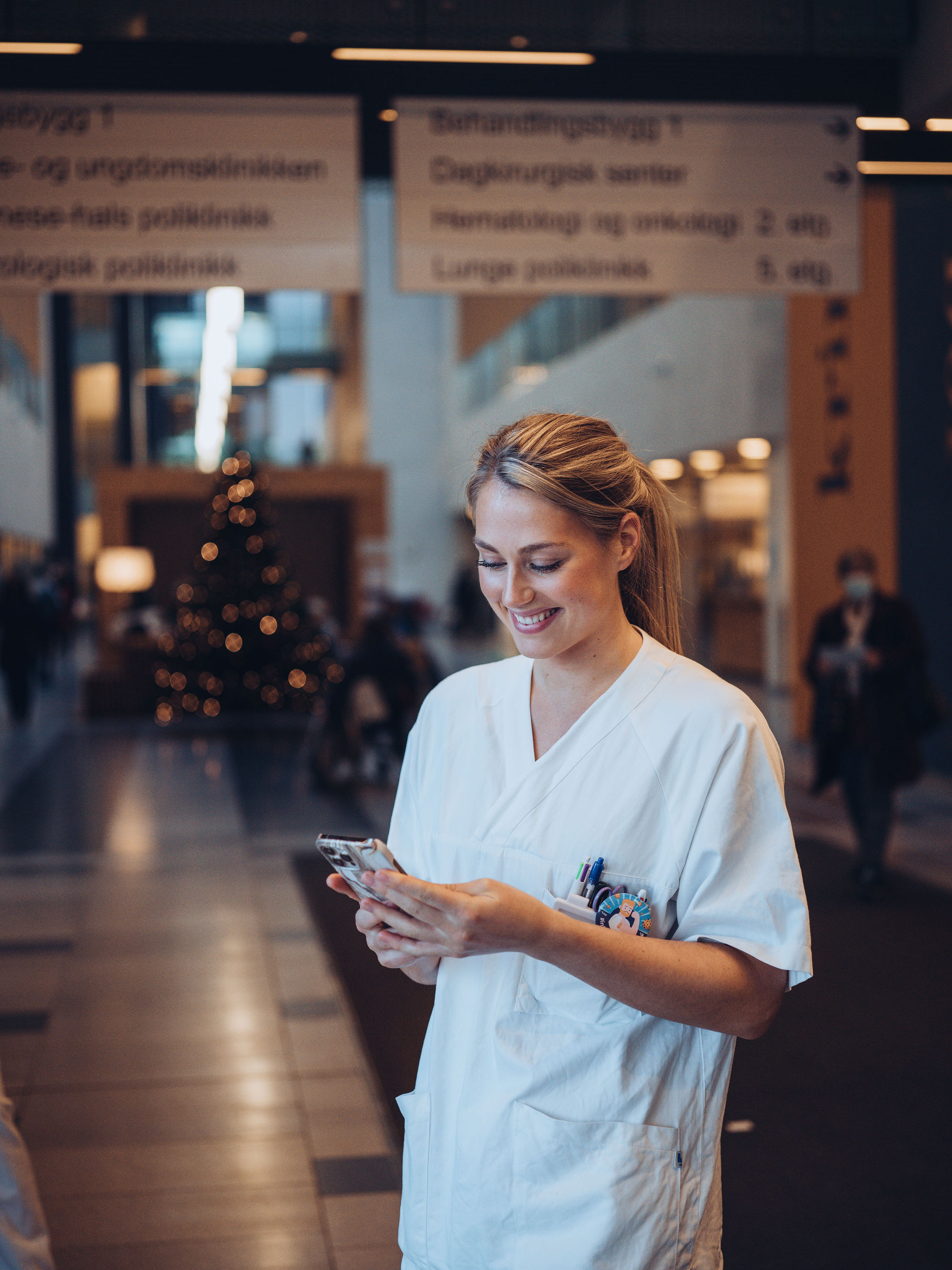 Sykepleiere ser på mobilen i alleen på Ahus