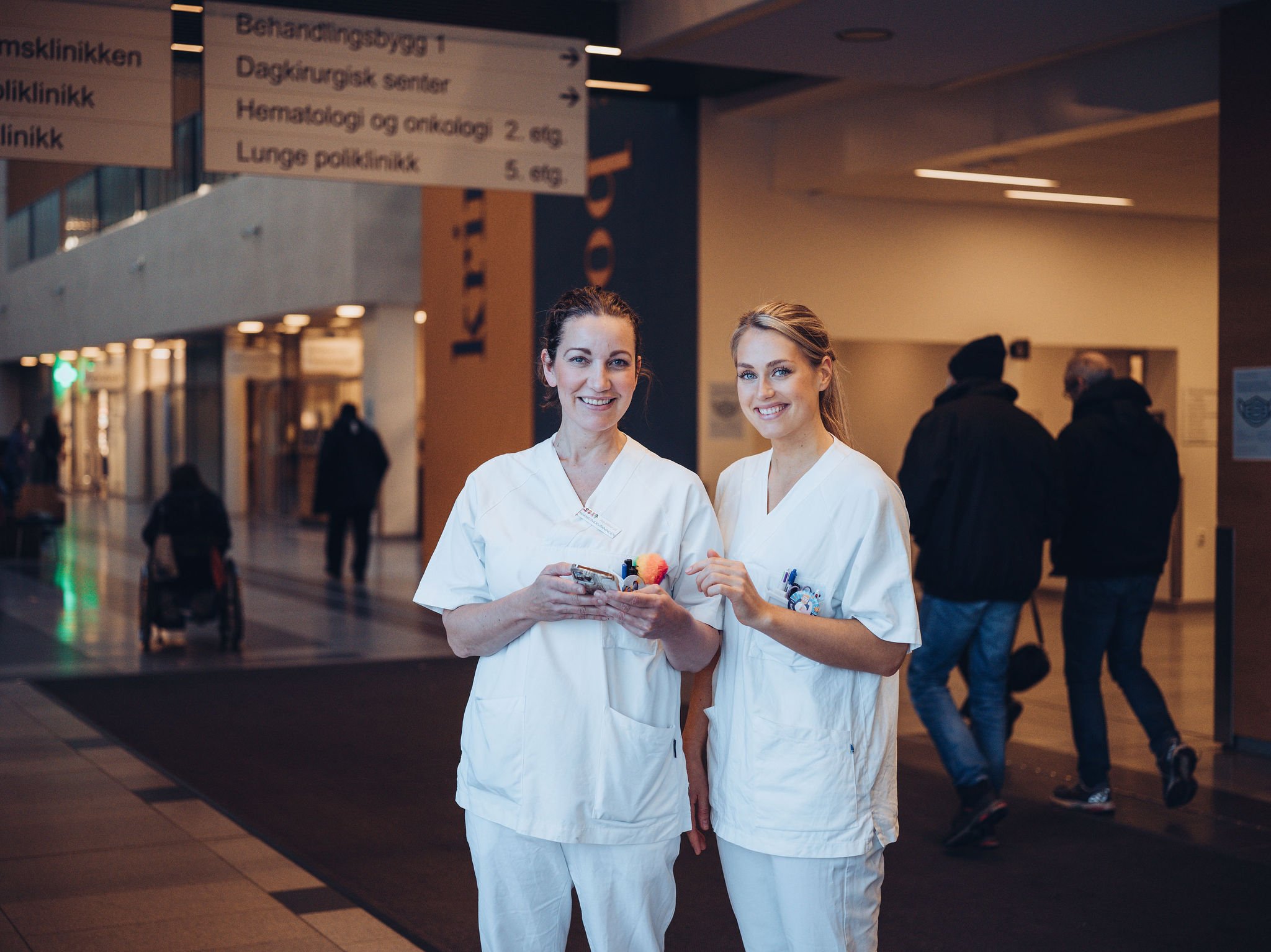 To sykepleiere med mobil i alleen på Ahus